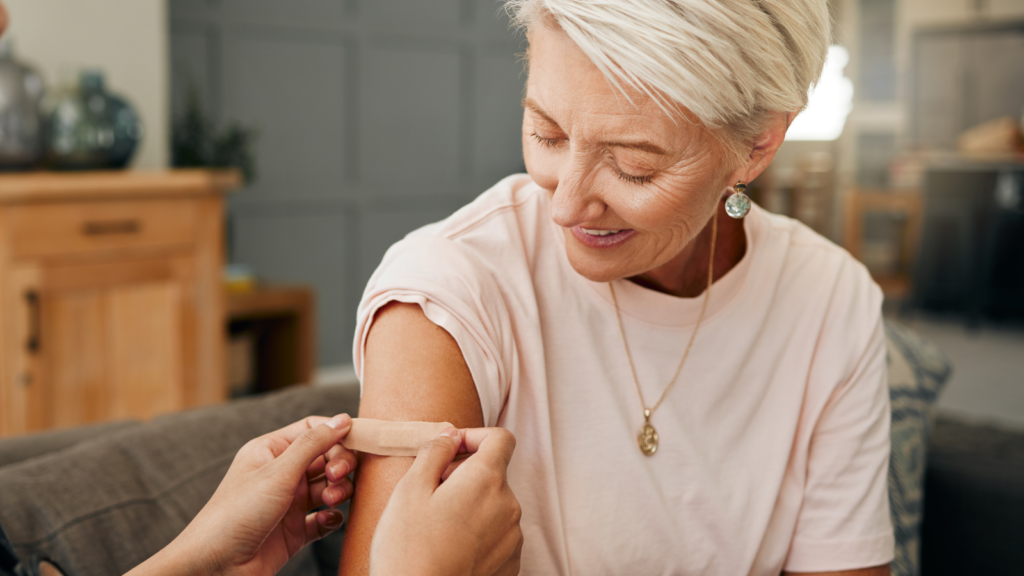 Bandaid being placed on woman's arm following immunization